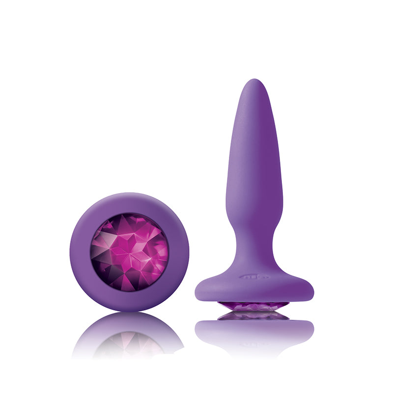 Photo of the Glams Mini Silicone Butt Plug from NS Novelties (purple/purple), shows the large gem on the base and the tapered shape of the plug.