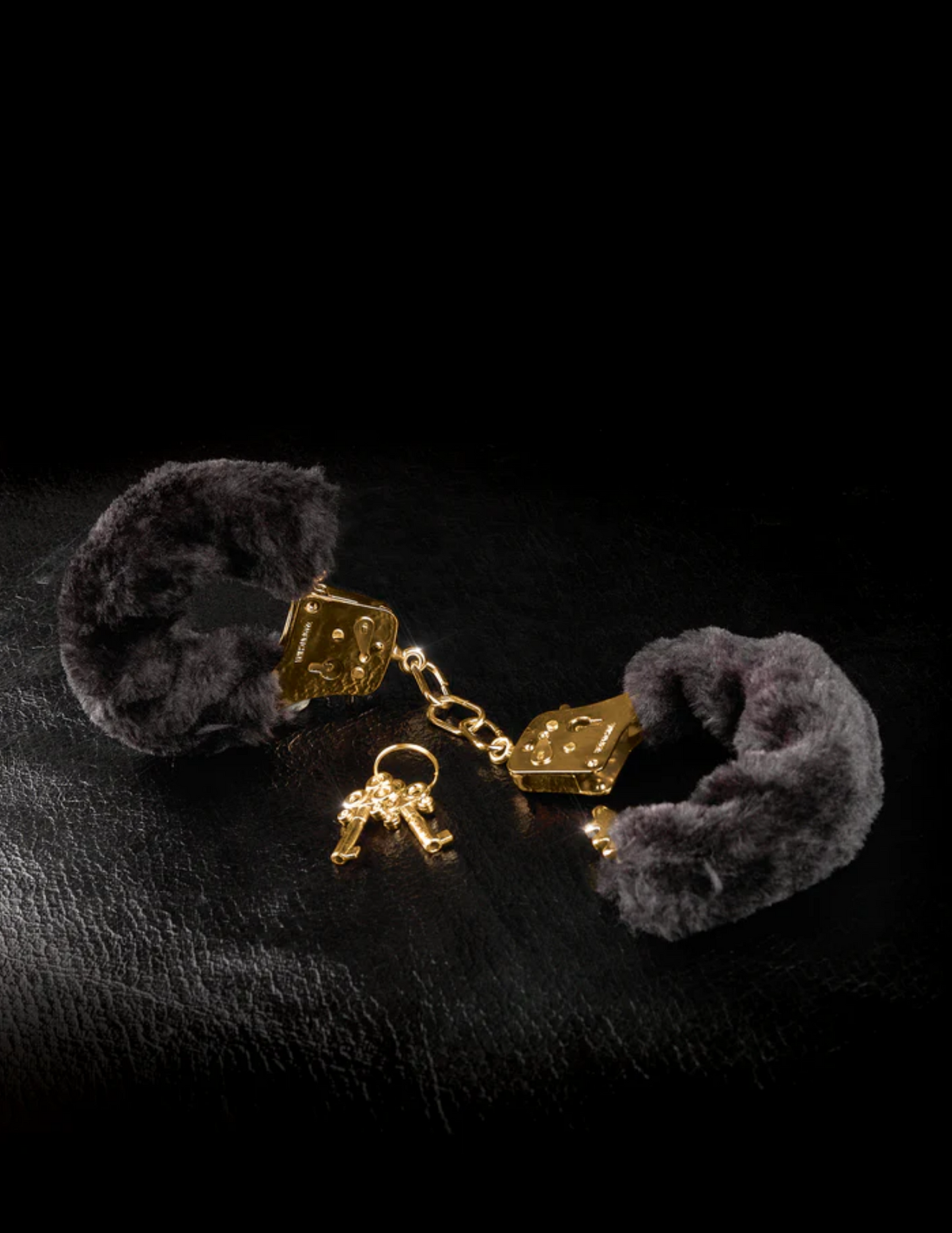 Photo of the Fetish Fantasy Gold Deluxe Furry Cuffs from Pipedreams (black/gold) showing off its gold hardware.