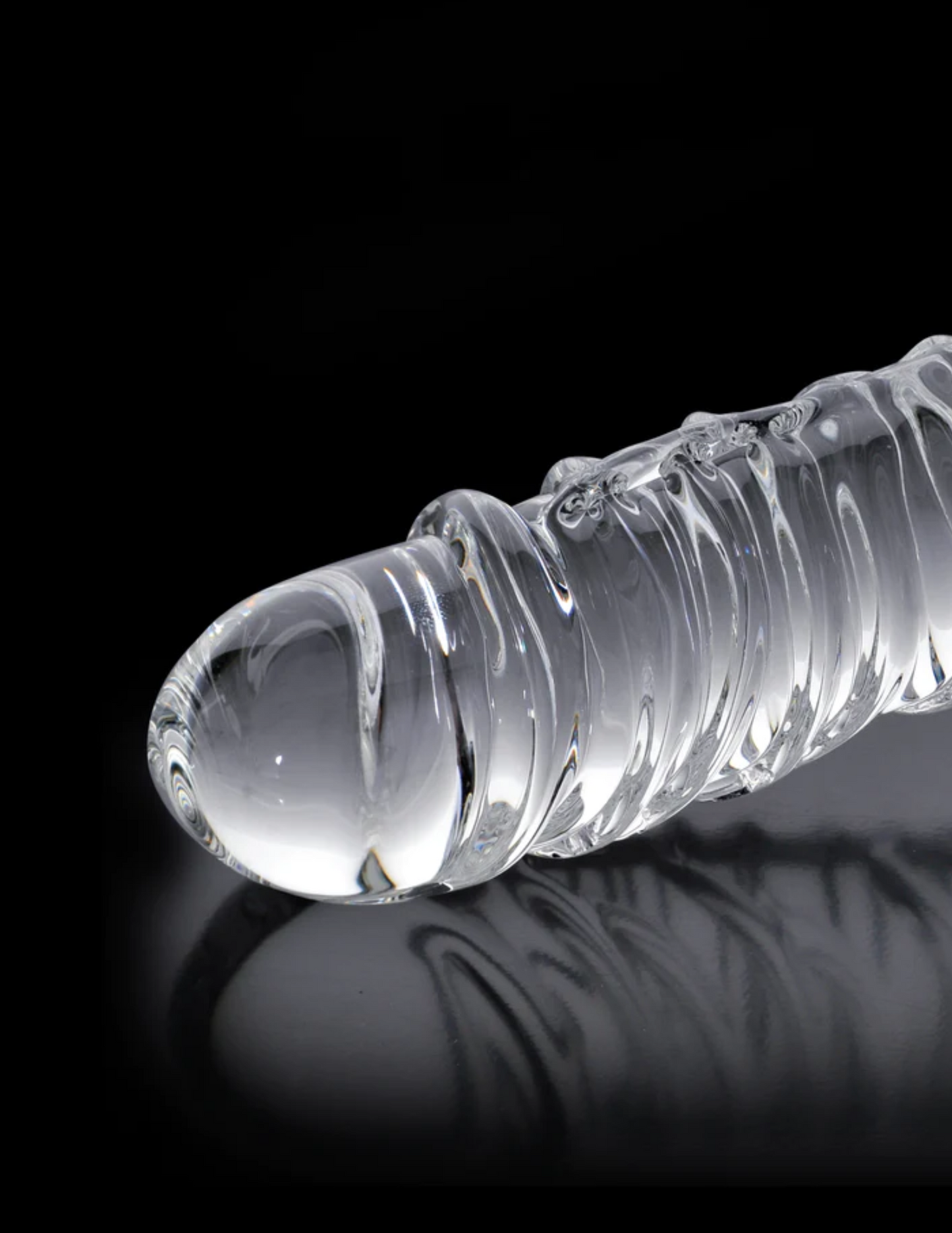 Close-up of the No. 63 Textured Glass Dildo w/ Balls from Pipedreams (clear) shows the head and swirled texture of the massager.