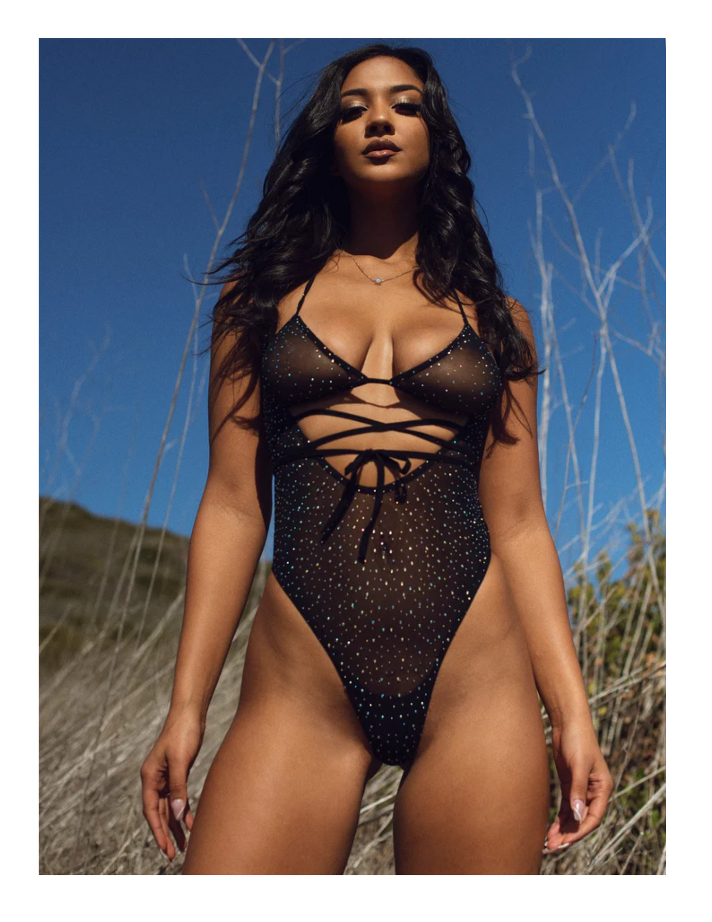 Ad with a model showing the Rhinestone Mesh Wrap Around Bodysuit from Leg Avenue (black, OS).
