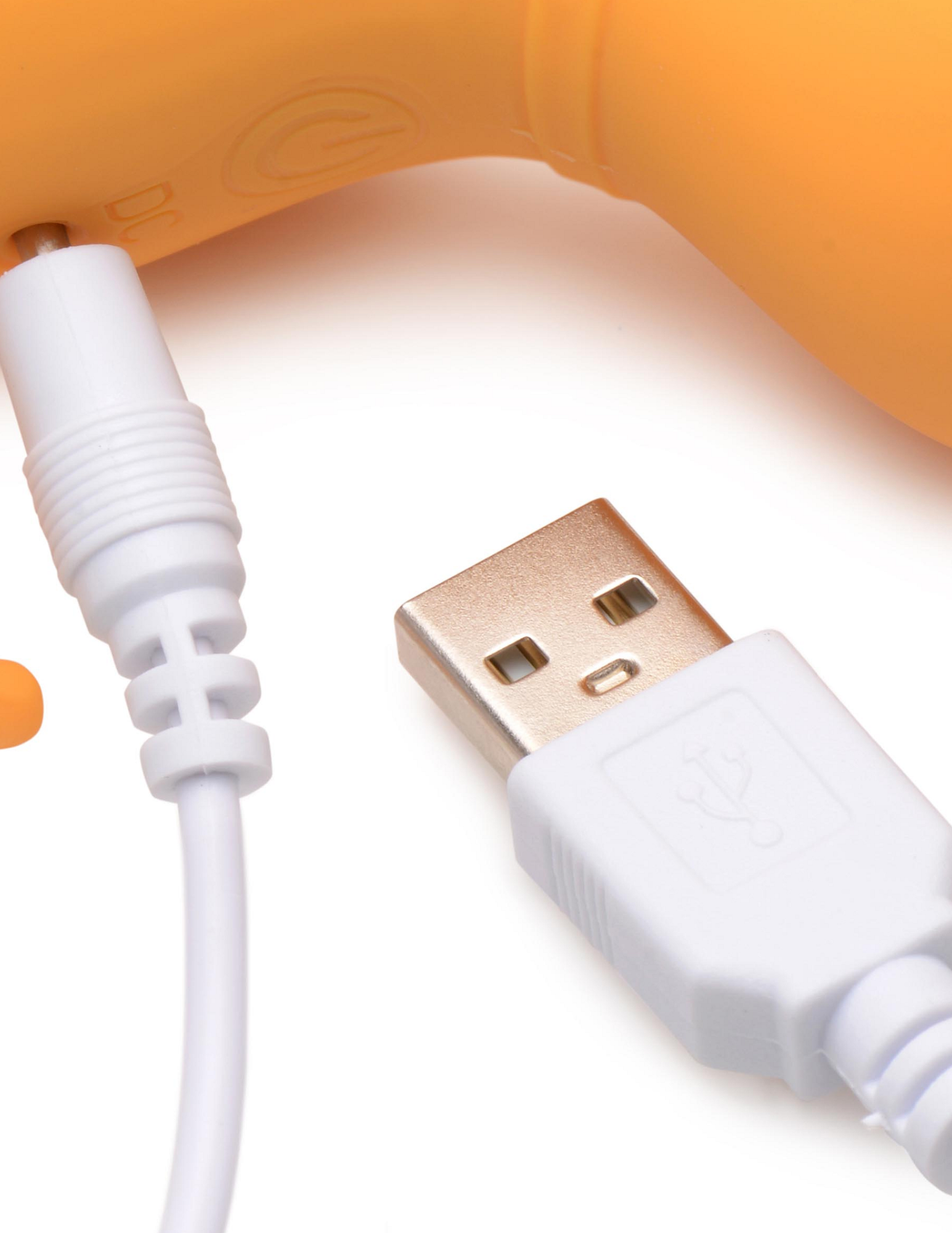 Close-up of the USB charging cord and port on the Shegasm Sucky Kitty Clitoral Stimulator from XR Brands (orange).