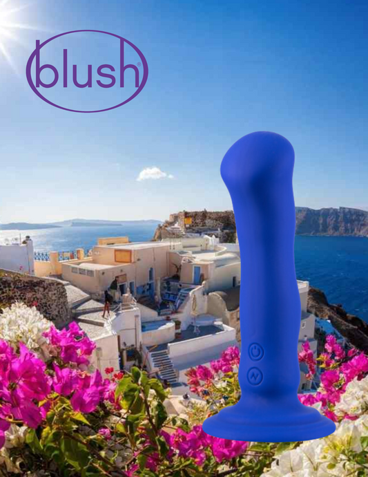 Image of the Impressions Santorini Vibrator from Blush (blue) in front of a photo of Santorini, Greece.