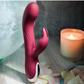 Close-up view of the Evolved Inflatable Bunny Rechargeable Silicone Dual Stimulating Vibrator with a candle.