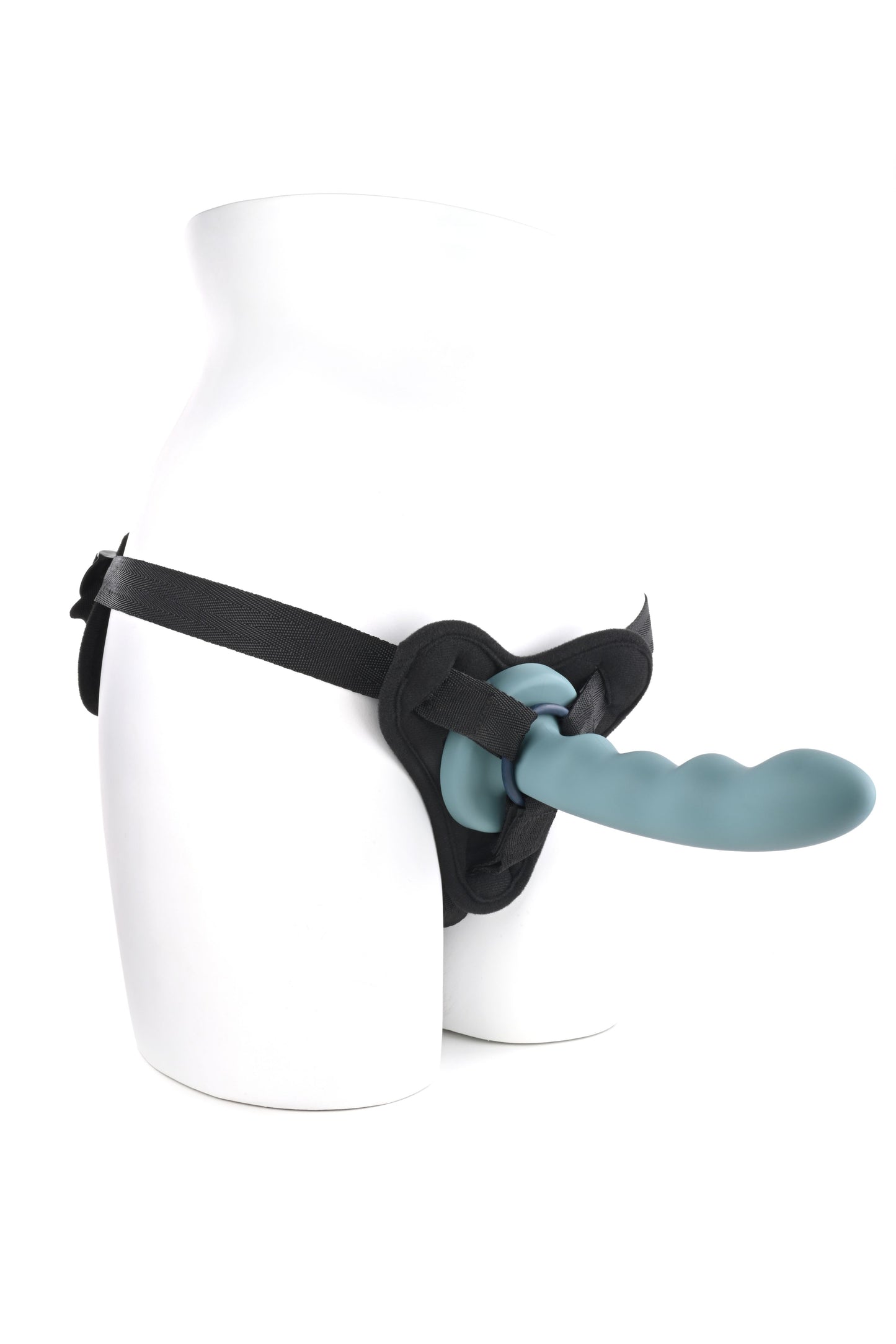 Side angle view of the bottom of a mannequin wearing a harness with a dildo and one of the o-rings to show how it is to be used.