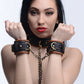 Woman wearing the product with her arms in front of her, displaying the wrist cuffs and chain. 