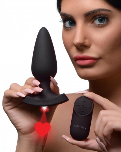 Woman holding the plug with the red laser heart image shining. She is also holding the remote.