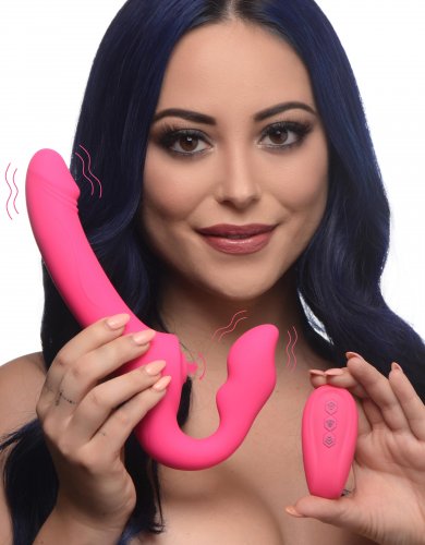 Woman holding the toy up-right and to the side. Wavy lines are drawn along the side of the vibrating bulb and dildo. She holds the remote in the other hand,