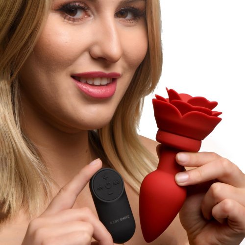 Woman holding the vibrating rose butt plug and remote control.