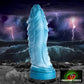 Sci-fi/fantasy image of the Scaly dildo on a dark rocky piece of land with rough, dark water, waves crashing up. The sky is an ominous black and blue with purple bolts of lightning. The bottom right-hand corner has a small logo image for Creature Cocks that is a close-up eye of a monster. 