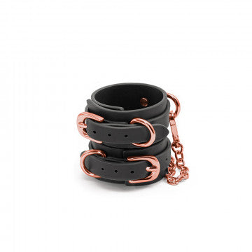 Front view of the Bondage Couture Wrist Cuffs from NS Novelties (black) shows their rose gold hardware and classy look.